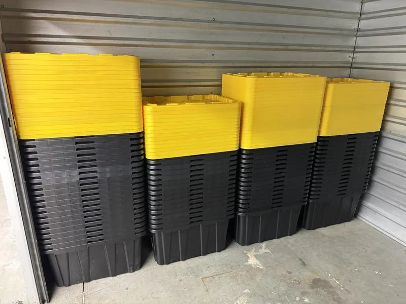 Nested black 27-gallon moving totes with stacks of yellow snap-on lids